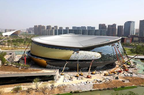 杭州亚运会乒乓球场馆建设现场,施工人员对乒乓球场馆外立面幕墙进行