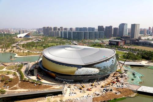 杭州亚运会乒乓球场馆建设现场,施工人员对乒乓球场馆外立面幕墙进行